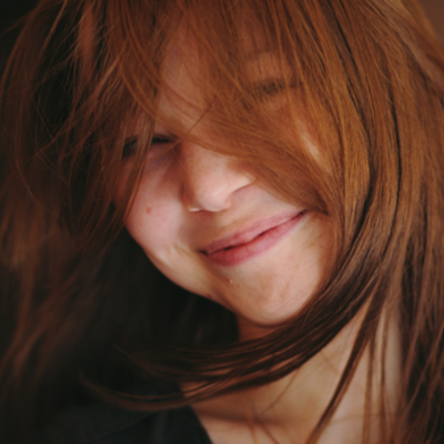 Ein Mädchen lächelt und hat verwuschelte Haare